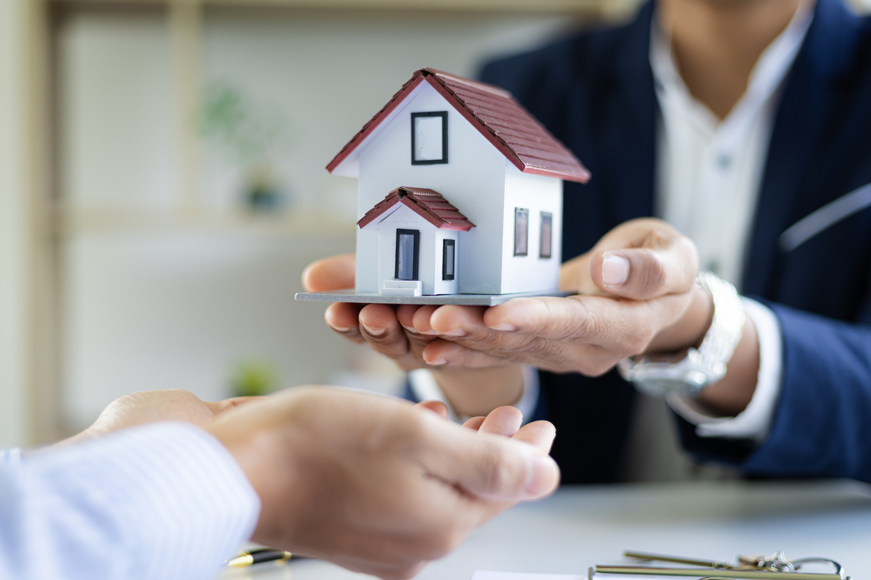 Real estate inheritance concept and contract agreement. The real estate agent offers the customer a model home after the legal purchase of the home is signed.